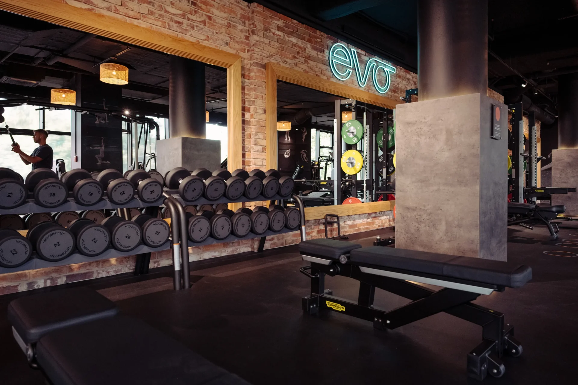 Dumbbell rack with reflection in mirror and EVO neon sign
