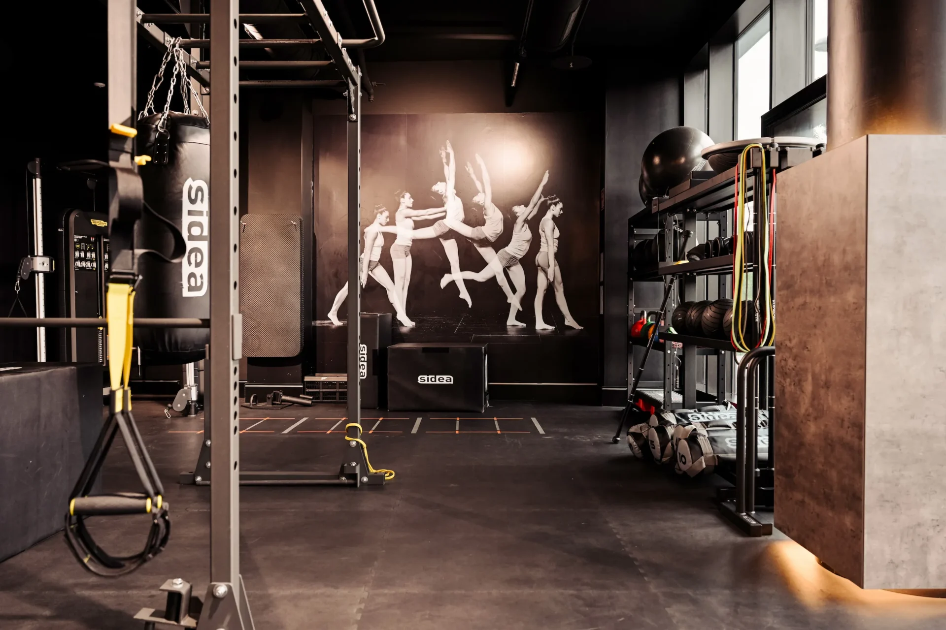 Functional zone with training rig, resistance bands and plyo boxes with wallart in the background at EVO Fitness Bel & Main