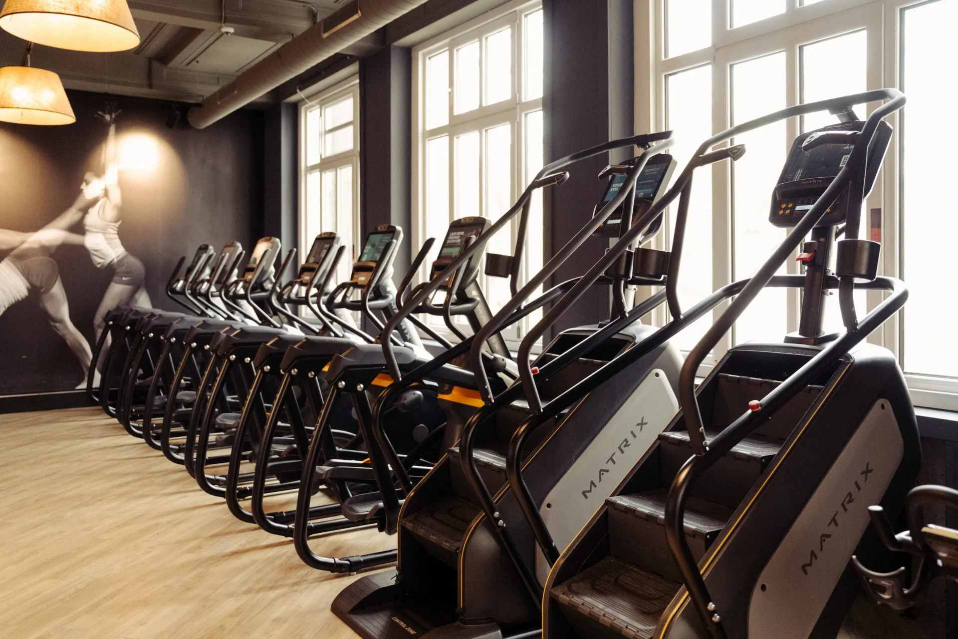 Matrix stair climbers and cardio equipment in front of windows at EVO Fitness