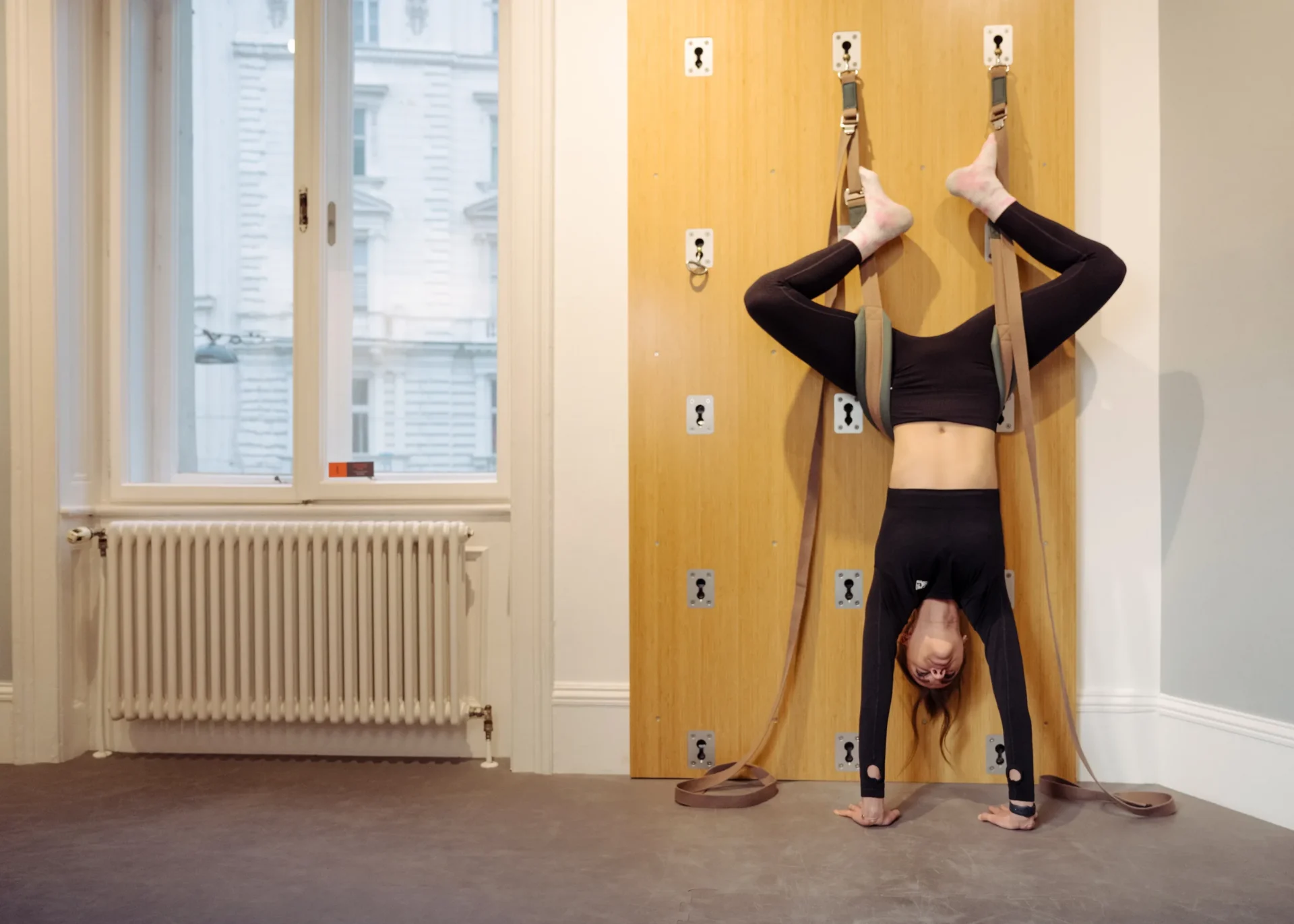 Woman stretching back using wooden wall bars at EVO