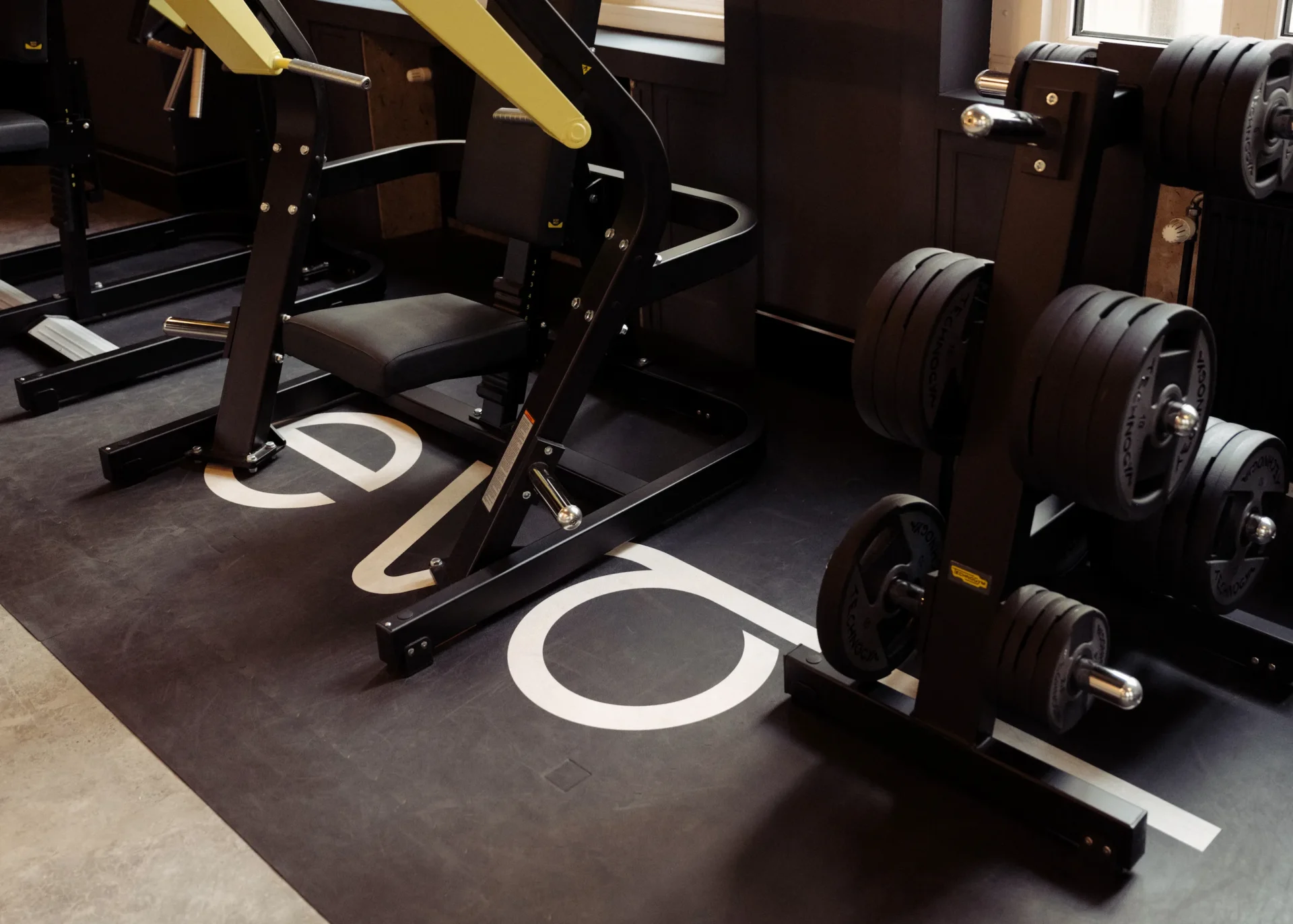 Close-up of gym machine and loaded weight plates on rack at EVO Fitness