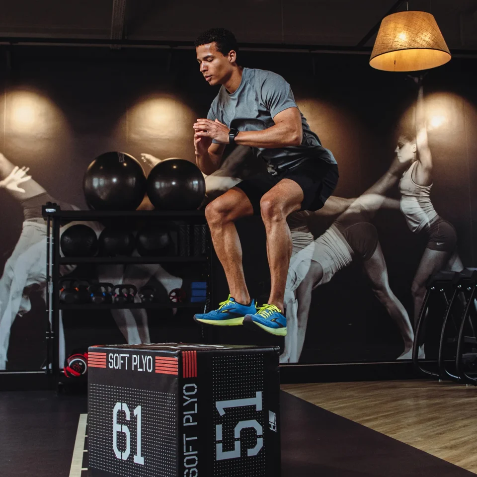 Man in sportswear jumping onto plyo box at an EVO Fitness.