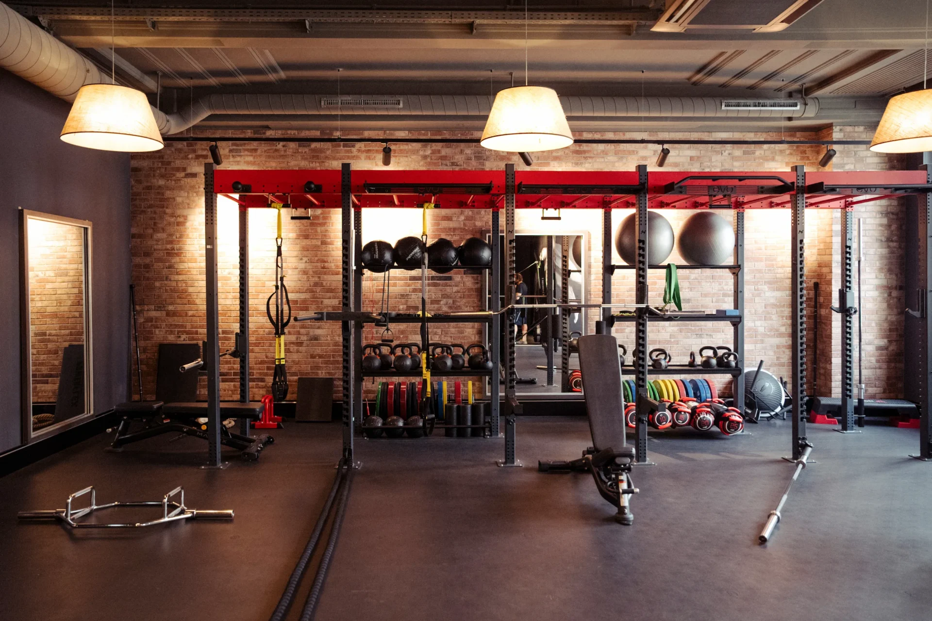 Rig training station with kettlebells, bars, and TRX setup at EVO Fitness
