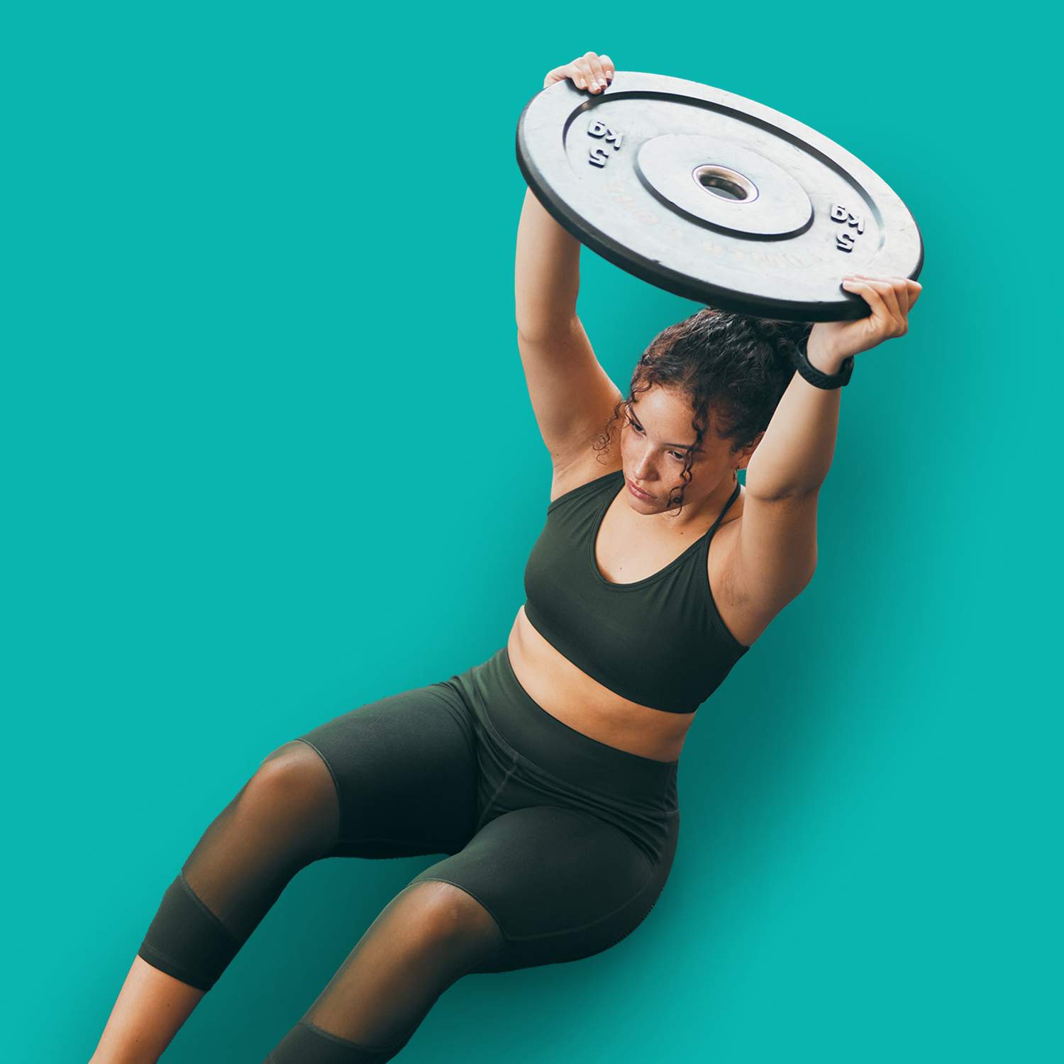 fitness, weight plate and woman at gym for workout, exercise and training for health and body wellness. top view of strong sports female or bodybuilder on floor weightlifting for power and balance, Frau in schwarzer Sportkleidung hebt Gewicht über den Kopf vor farbigem EVO Hintergrund