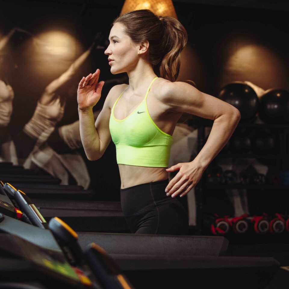 Athletic woman running on treadmill