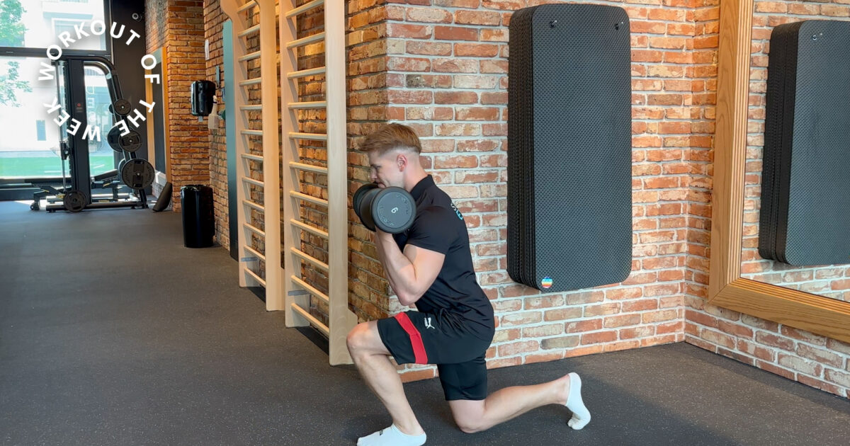 20-min dumbbell compound workouT - Man performing a weighted lunge with dumbbells in the functional training area of EVO Fitness, surrounded by wooden wall bars and soft lighting on exposed brick walls.