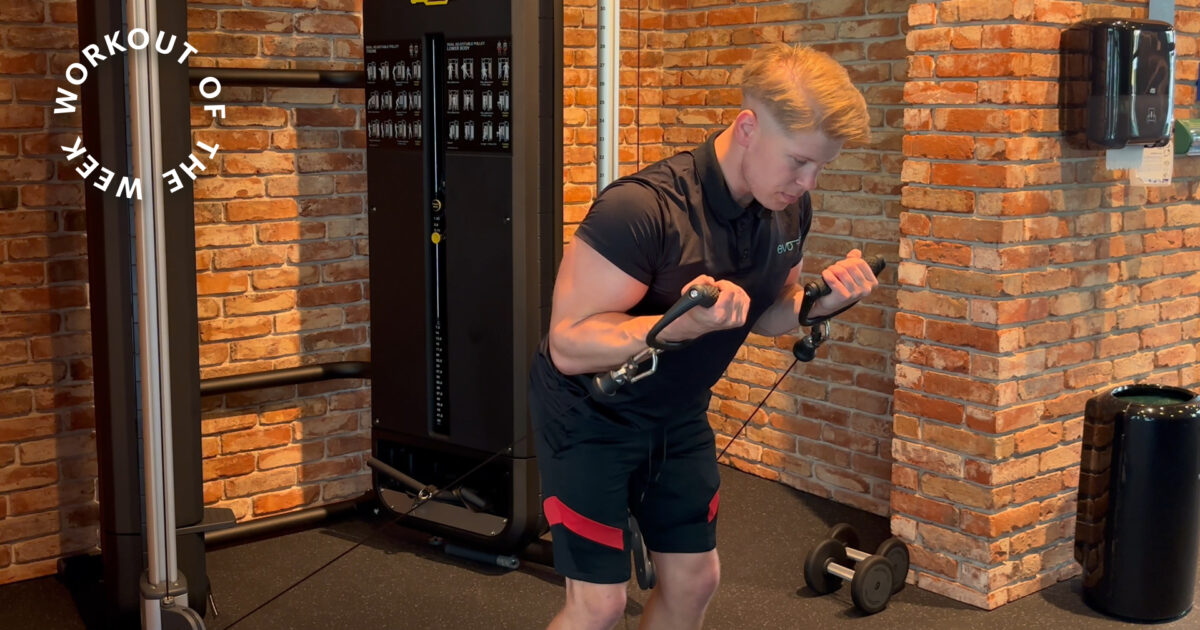 25-min bicep and tricep workout - Man performing bent-over cable curls in the strength training area of EVO Fitness, with brick walls and sleek cable machine creating a focused and modern environment.