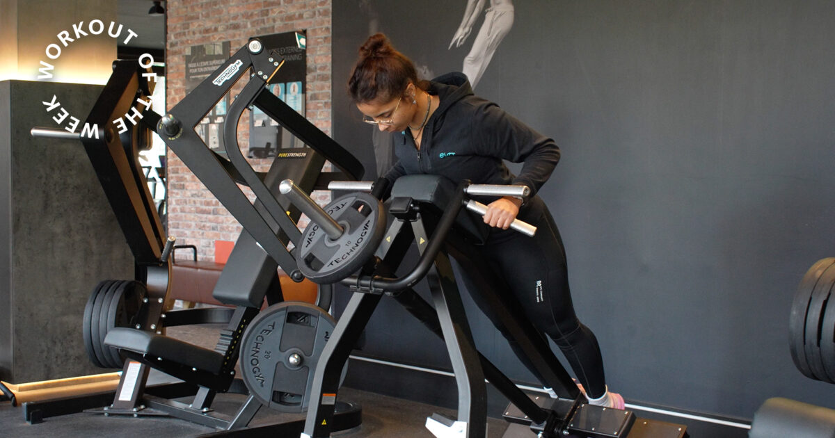 Woman training her back on a plate-loaded strength machine at EVO Fitness.