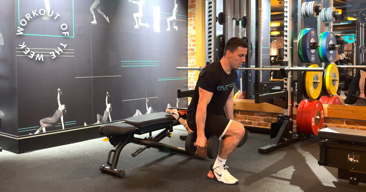 Man performing a dumbbell lunge during a unilateral strength workout at EVO Fitness.