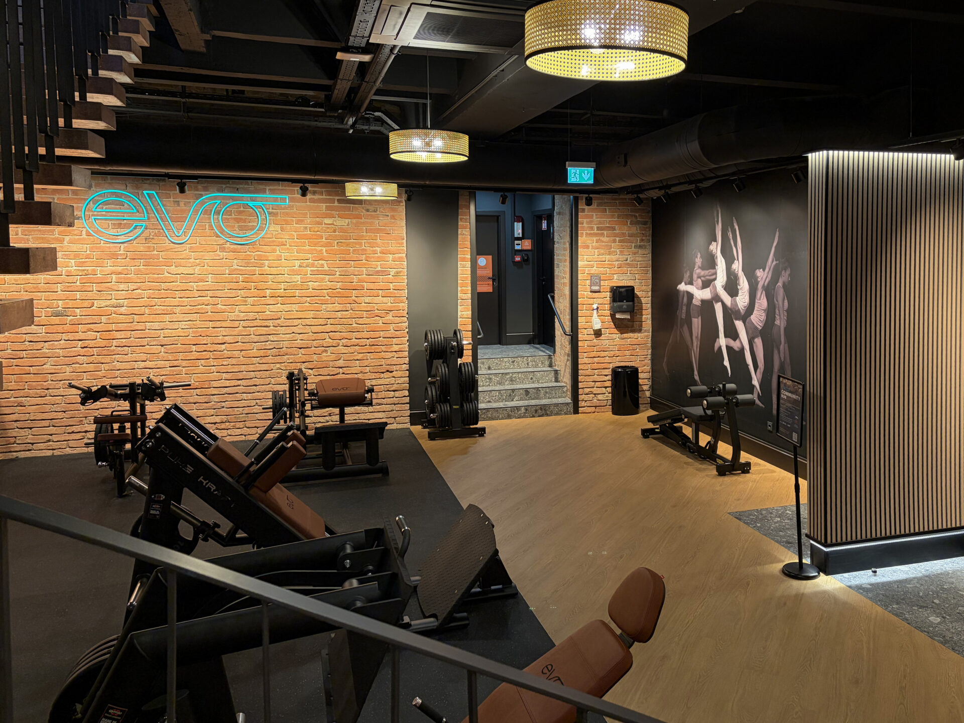 Strength training area with premium gym equipment and brick walls at EVO Fitness Vienna Praterstrasse.