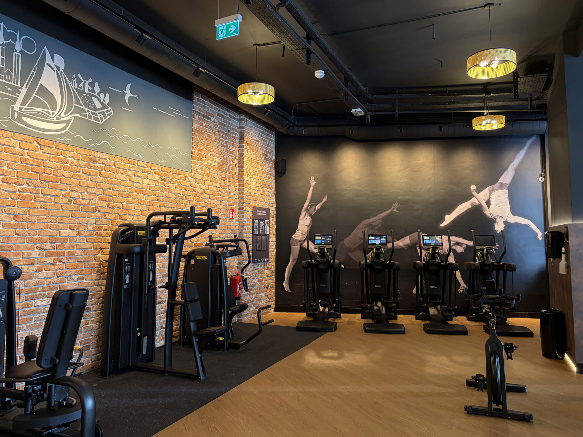Cardio area with cross trainers, exercise bikes and strength equipment at EVO Fitness Vienna Praterstrasse.